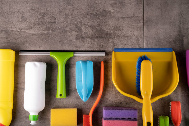 House  and office cleaning products. Colorful cleaning kit on gray tiles background. - Fotó, kép