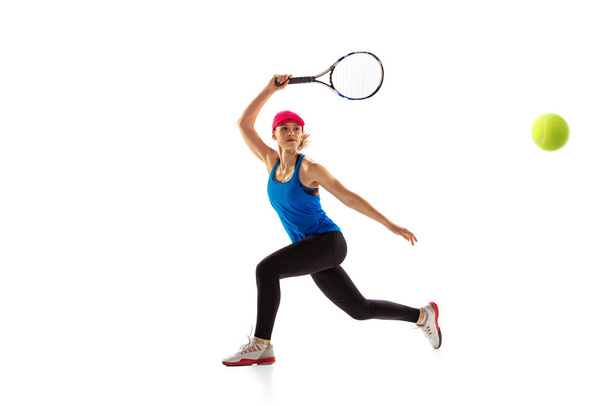 Portrait of young sportive woman, tennis player playing tennis isolated on white background. Healthy lifestyle, fitness, sport, exercise concept. Female athlete in motion, action or movement - Foto, Imagem
