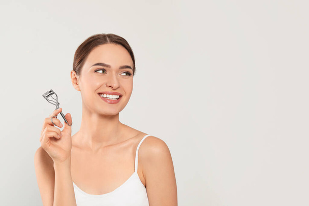 Woman with eyelash curler on white background, space for text - Φωτογραφία, εικόνα