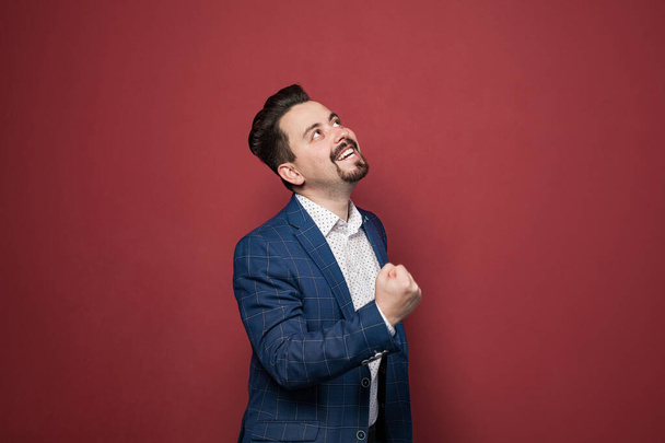 Portrait of playful bearded businessman having fun and looking up. Men wearing official style suit. Indoor studio shot - Photo, image