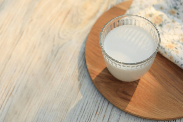 Glass of tasty fresh milk on white wooden table, above view. Space for text - Φωτογραφία, εικόνα