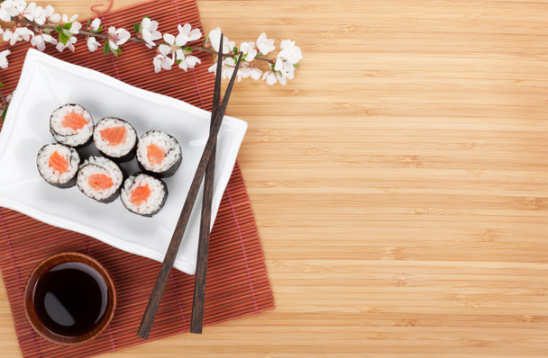 Sushi maki with salmon and sakura branch - Photo, Image