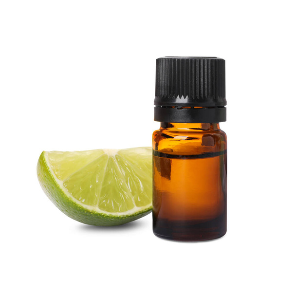 Bottle of citrus essential oil and cut fresh lime isolated on white - Foto, afbeelding