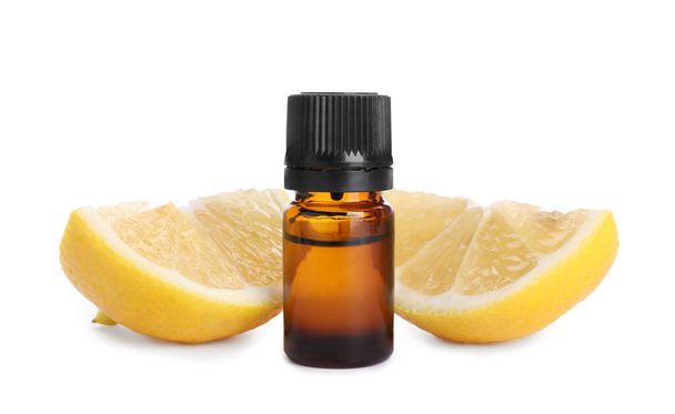 Bottle of citrus essential oil and cut fresh lemon isolated on white - Photo, image