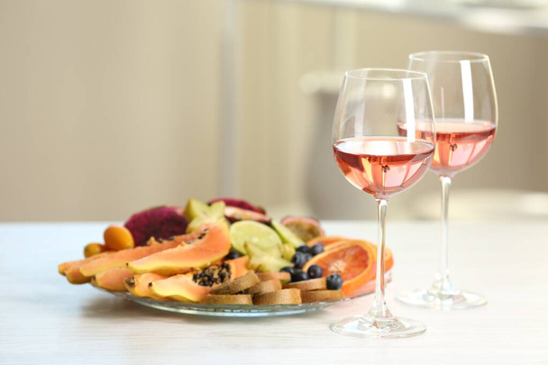 Delicious exotic fruits and wine on white table - 写真・画像