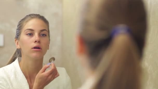 Pretty woman applying make up - Кадры, видео