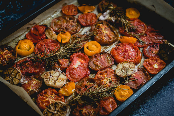 Metal tray with roasted with garlic and herbs different color and kinds tomatoes. Top view, flat lay - Fotografie, Obrázek