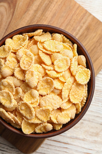 Bowl of tasty corn flakes on wooden table, top view - Foto, Imagem