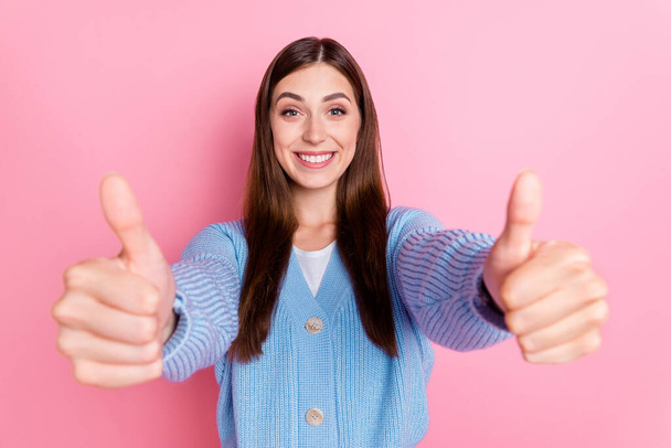 Photo of satisfied beaming cheerful girl with long hairdo showing thumbs up like it recommendation isolated on pink color background. - Photo, image