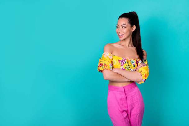 Photo of lovely young brunette lady crossed arms look promotion wear printed top pants isolated on teal background. - 写真・画像