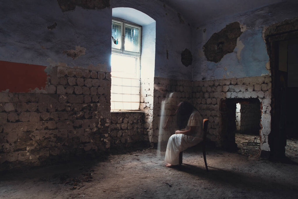 Ghost in abandoned, haunted house. Horror scene of scary spirit of a woman, halloween concept. - Fotó, kép