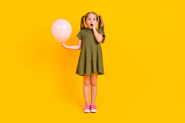 Full size photo of impressed funny person hold air balloon hand touch cheek isolated on yellow color background. - Fotoğraf, Görsel