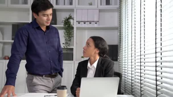 Concept of experienced and competent coworker, employer, supervisor giving advice to a young female office worker. Teamwork between coworkers, leadership company, multiracial in workspace. - Séquence, vidéo