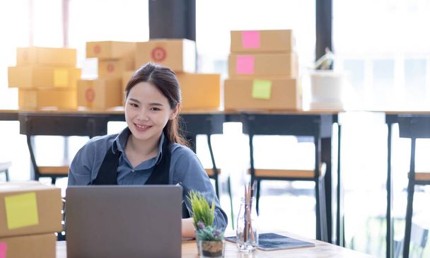 Portrait of Starting small businesses SME owners, Asian woman check online orders Selling products online and working with boxs freelance work at home Asian sme business online small medium enterpris - Foto, imagen