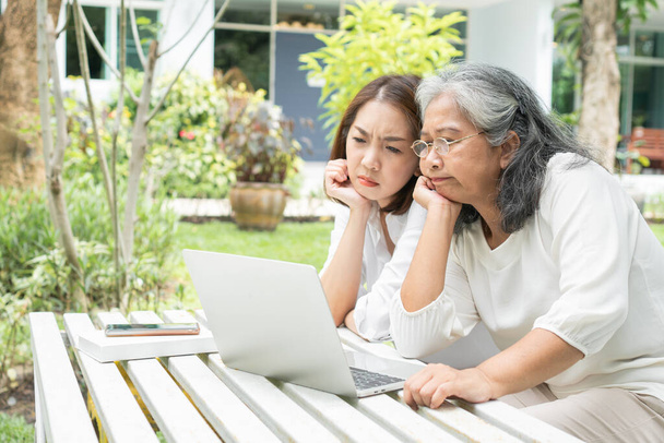 Yaşlı kadınlara ders veren Asyalı kız çocuğu emeklilikten sonra bilgisayar bilgisayarında sosyal medya kullanıyor. Öğrenme teknolojisi ve yaşlıların adaptasyonu kavramı - Fotoğraf, Görsel