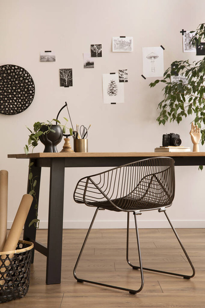 The stylish composition of cozy office interior with metal chair, wooden table, plants, pictures and personal accessories. Home decor. Template.  - Foto, Imagem