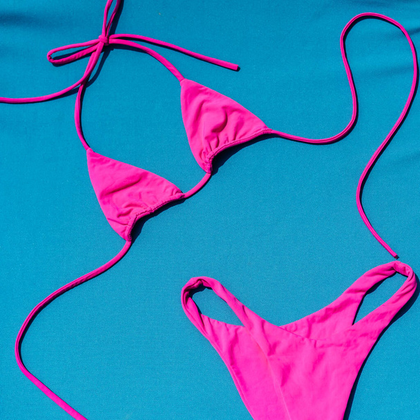 From Above Photo Of Pink Bikini On A Blue Background - Foto, Bild