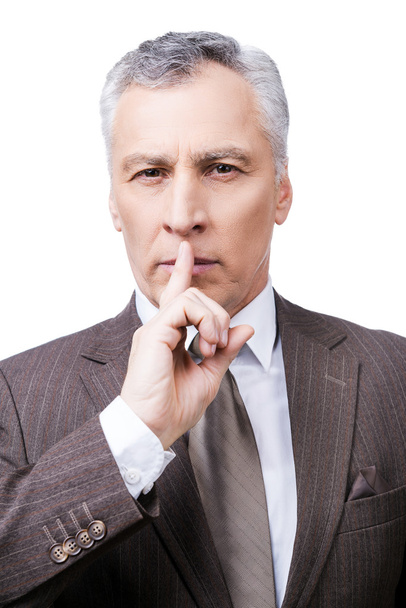 Mature man in formalwear holding finger on lips - Foto, Imagen