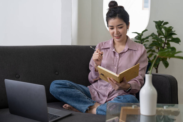 Азійська молода жінка за допомогою слухання ноутбуків і вивчення онлайн-курсів удома. - Фото, зображення