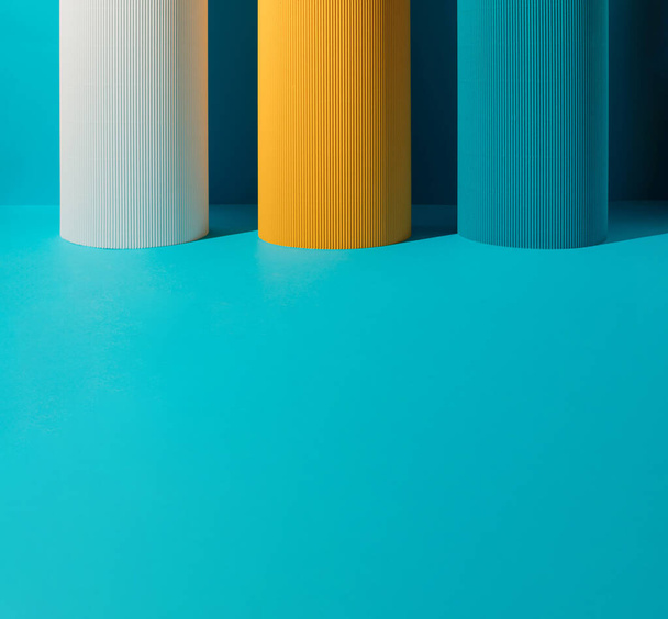 Three paper pillars - white, yellow and blue on blue background with copy space. - Zdjęcie, obraz