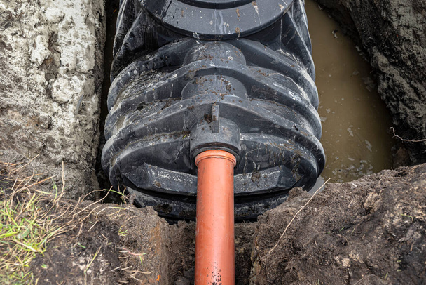 A sewer pipe with a diameter of 160 mm enters the septic tank tank, installation of a single-chamber home sewage treatment plant. - Zdjęcie, obraz