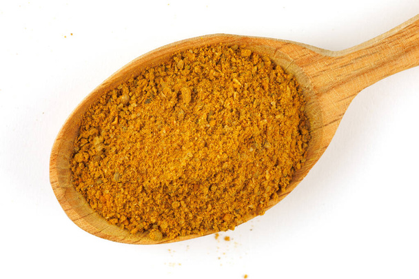 Curry powder seasoning in a wooden spoon isolate - Foto, Bild