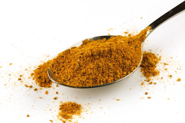 Curry powder seasoning in a metal spoon - Valokuva, kuva