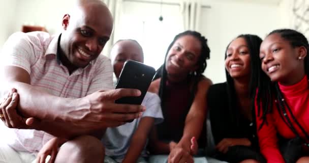 Szczęśliwa rodzina przegląda zdjęcie na smartfonie, czarny afrykański pochodzenie etniczne - Materiał filmowy, wideo