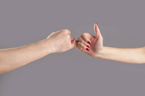 Hand to pinky swear,Happy couple or friendship holding hands together forever. Finger two hands hold together. Show friendship and forgiveness. Man and woman do Pinky promise or pinky swear hands. - Foto, afbeelding
