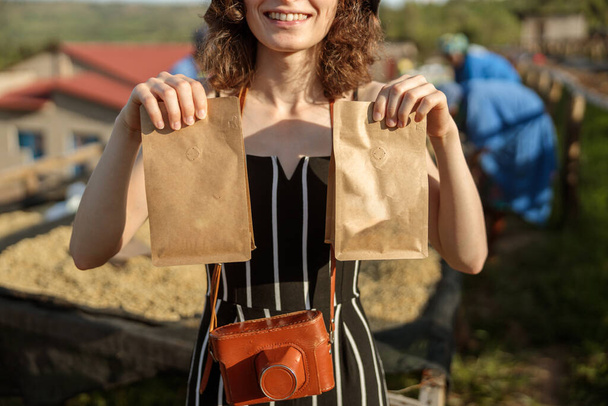 Cropped photo of happy lady holding two paper bags with coffee beans at coffee farm - Foto, Bild