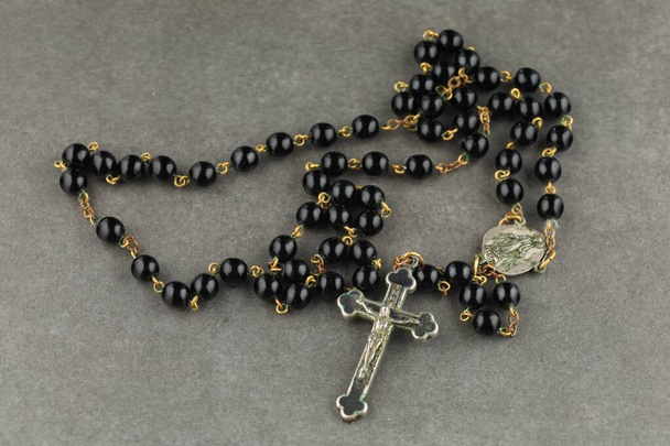 Catholic rosary beads. black rosary close-up - Foto, afbeelding