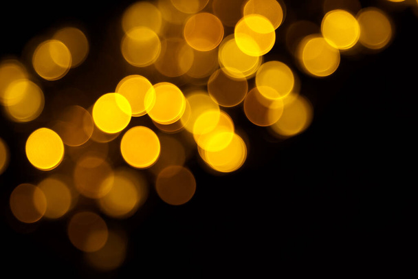 Abstract gold bokeh on black background. Defocused yellow lights, abstract texture. - Fotoğraf, Görsel