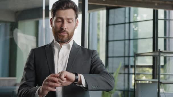 Portrait angry worried bearded 40s Caucasian businessman male frustrated boss manager waiting meeting in office nervous shake head with annoyance frustrated pointing finger on wrist watch late time - Video, Çekim