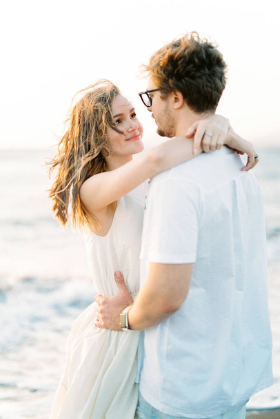 Man hugs woman by the waist and looks into her eyes. Portrait. High quality photo - Photo, image