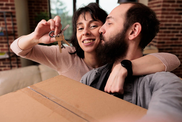 Life partners buying first house together and having keys, being property homeowners to start new beginnings. Celebrating relationship event with household relocation, moving in. - Fotoğraf, Görsel