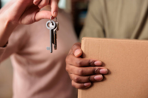 Diverse man and woman buying first house together and having keys, celebrating life achievement and relationship event. Moving in new apartment property and being excited about future. Close up. - Foto, Imagen