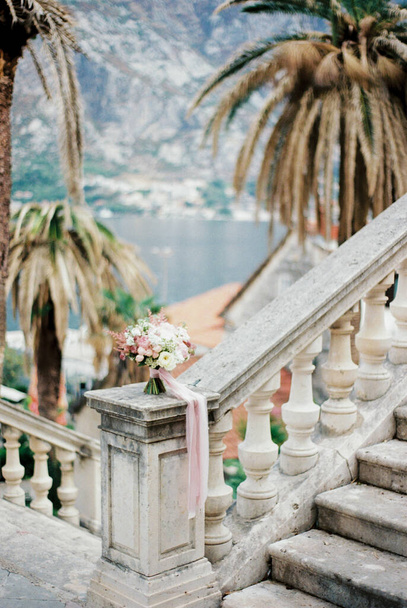Wedding bouquet stands on a balustrade overlooking the sea and mountains. High quality photo - Foto, immagini