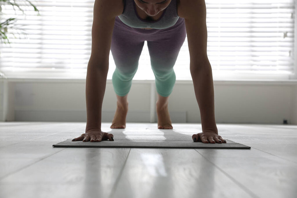 Woman practicing plank asana in yoga studio, closeup. Phalankasana pose - Zdjęcie, obraz