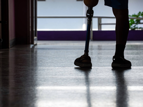 Behind the man wearing prosthetic legs walked out the door. - Photo, image