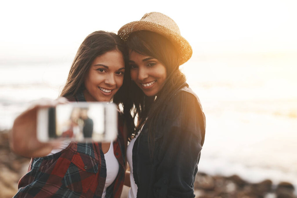 Στιγμιότυπα καλοκαιρινών αναμνήσεων. δύο νεαροί φίλοι βγάζουν μια selfie μαζί στην παραλία - Φωτογραφία, εικόνα