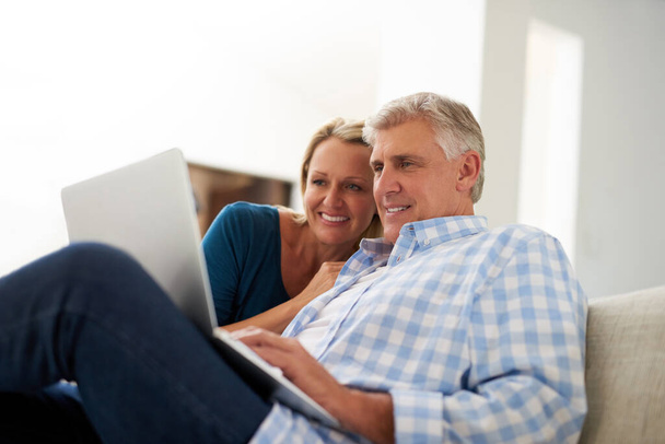 Browsing through the wide world online. a mature couple using a laptop together at home - Photo, image
