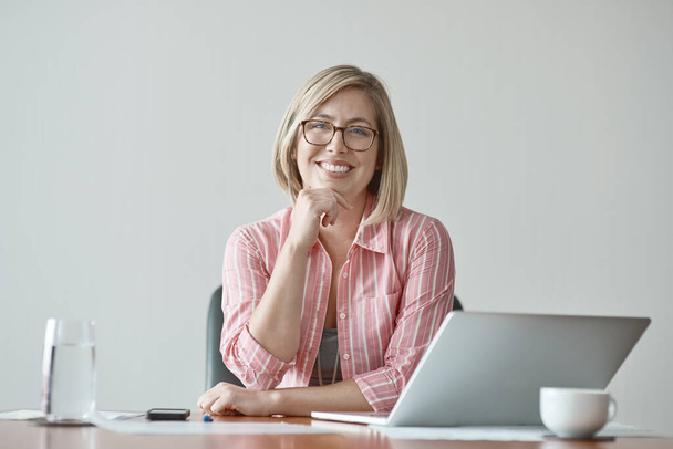 I firmly believe Ive got what it takes. Studio portrait of a confident businesswoman sitting at a desk against a grey background - Zdjęcie, obraz