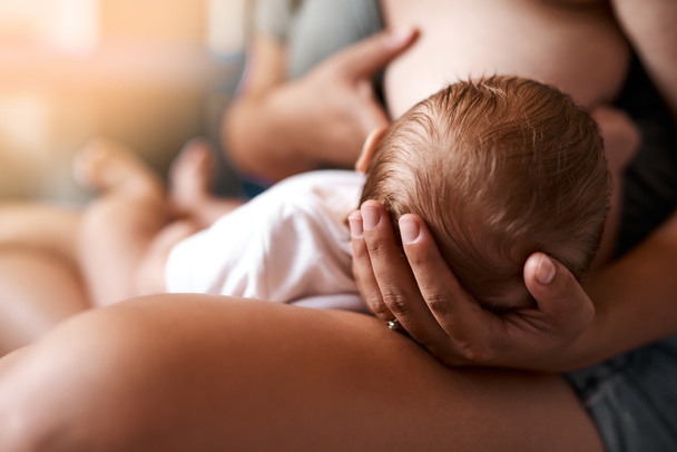 Το στήθος είναι καλύτερο για τη μαμά και το μωρό. Υψηλής γωνίας πλάνο μιας νεαρής μητέρας που θηλάζει το νεογέννητο μωρό της στο σπίτι - Φωτογραφία, εικόνα