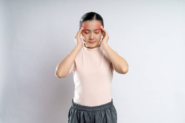 Asian woman was sick with headache touching her head with red spot and standing isolated on white background. - Foto, Imagen