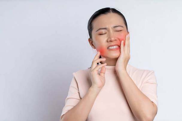 Asian woman was sick with toothache touching her cheek with red point and standing isolated on white background. - Photo, Image