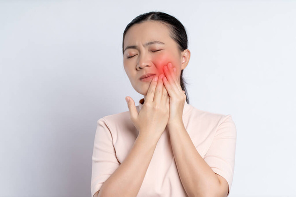 Asian woman was sick with toothache touching her cheek with red point and standing isolated on white background. - Foto, Bild