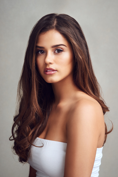 Wear your hair with confidence. Studio shot of a young beautiful woman with long gorgeous hair posing against a grey background - Foto, afbeelding