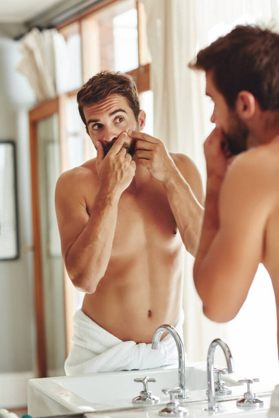 Позбавлення від небажаних вад. без сорочки молодий чоловік вискакує прищі у дзеркалі ванної кімнати
 - Фото, зображення