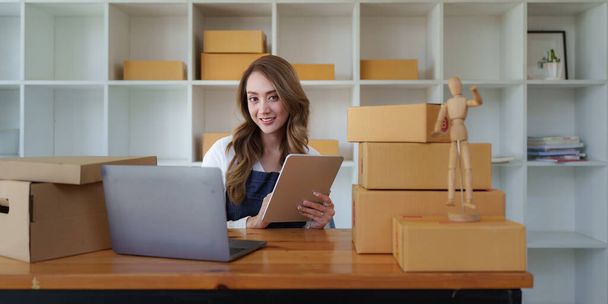 Attractive Asian SME business woman working at home office. online shopping concept. - 写真・画像