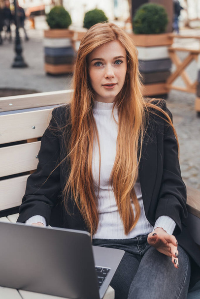 Πορτραίτο με θέα μπροστά, νεαρή γυναίκα με φακίδες, χέρια στο πληκτρολόγιο, πληροφορίες περιήγησης στο λάπτοπ του υπολογιστή, να κάθεται στο πάρκο της πόλης. Εκπαιδευτικό Διαδίκτυο - Φωτογραφία, εικόνα